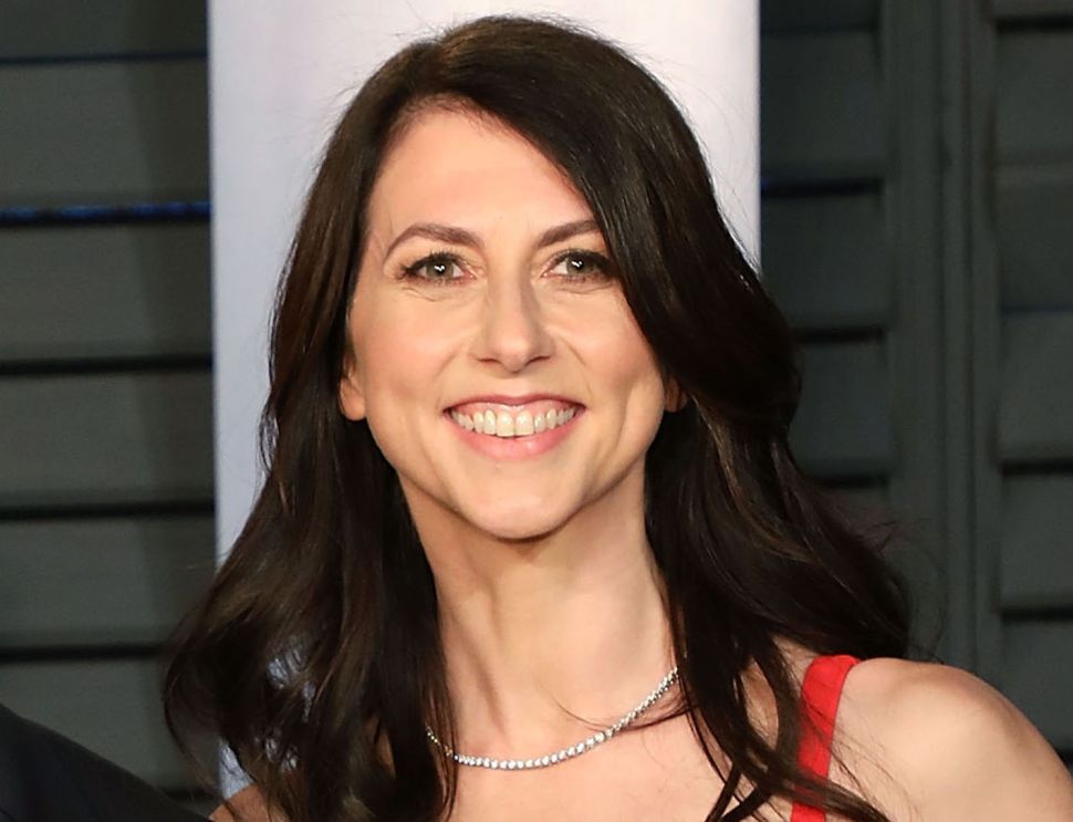MacKenzie Scott poses on red carpet in red dress.