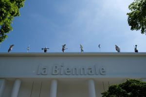 Entrance of a neoclassical white building with written Biennale