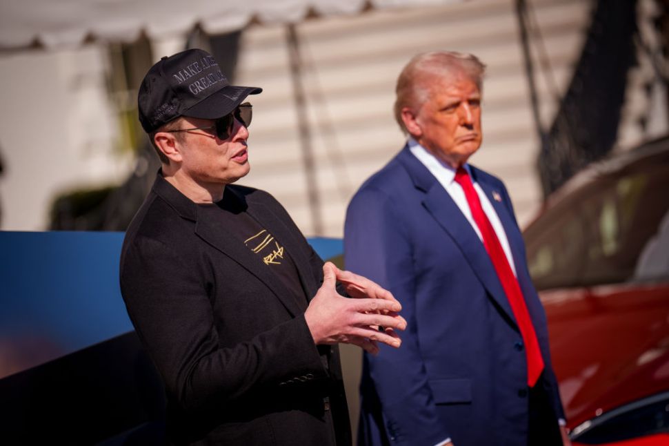 U.S. President Donald Trump listens as White House Senior Advisor, Tesla and SpaceX CEO Elon Musk, speaks next to a Tesla Cyber Truck and a Model S on the South Lawn of the White House
