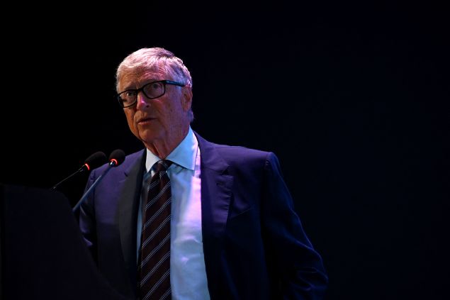 Man in suit stands on stage