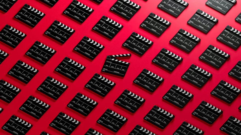 repeating pattern of film slates against a red background; a slate in the middle is open