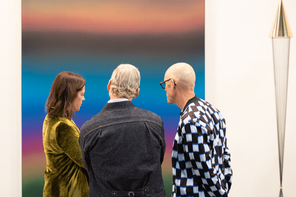 People looking at an abstract painting.